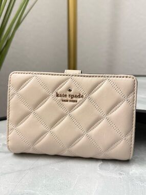 Kate Spade New York cream quilted compact wallet with gold logo